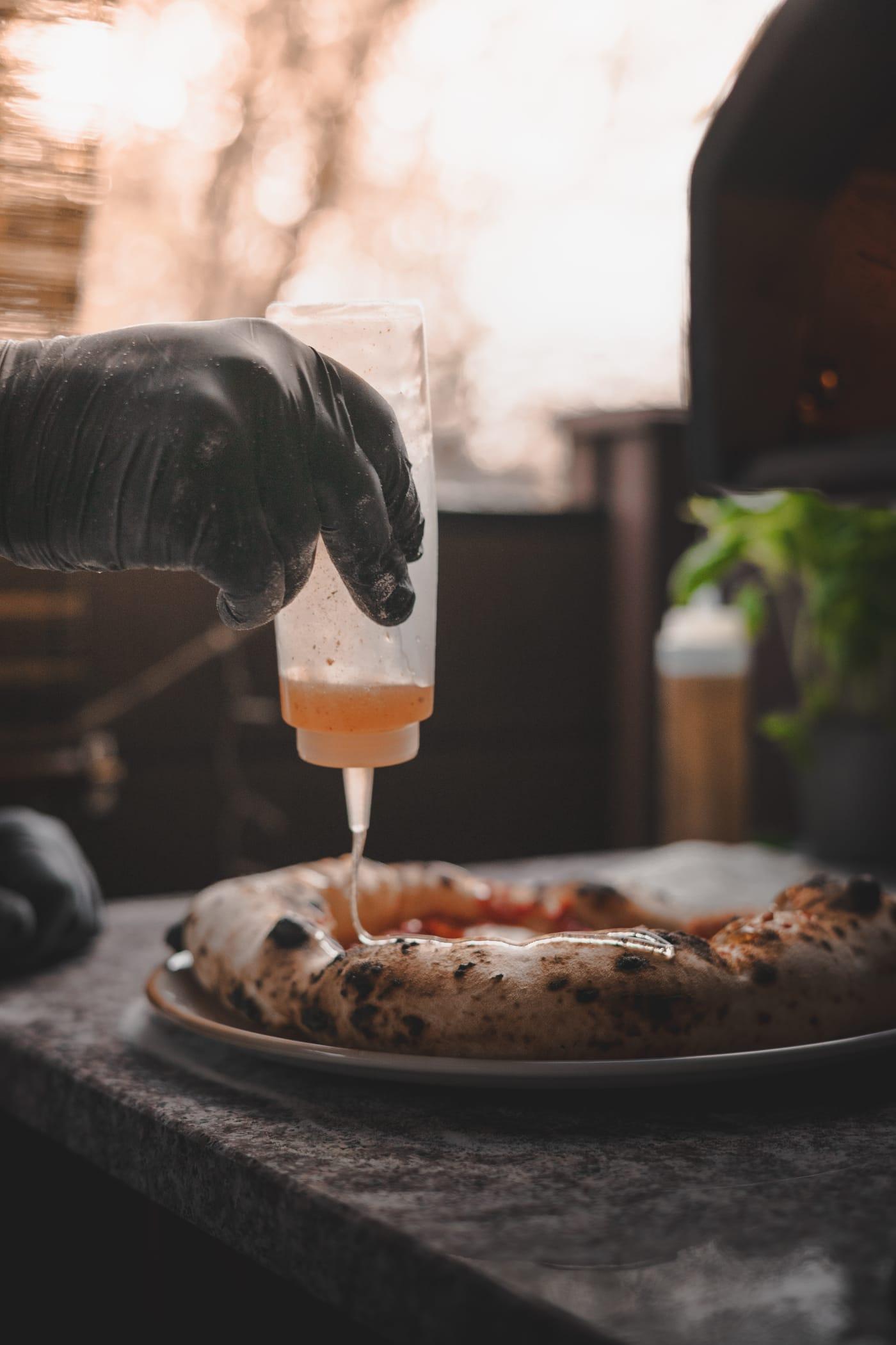 Olaj csorog a frissen sült pizzára